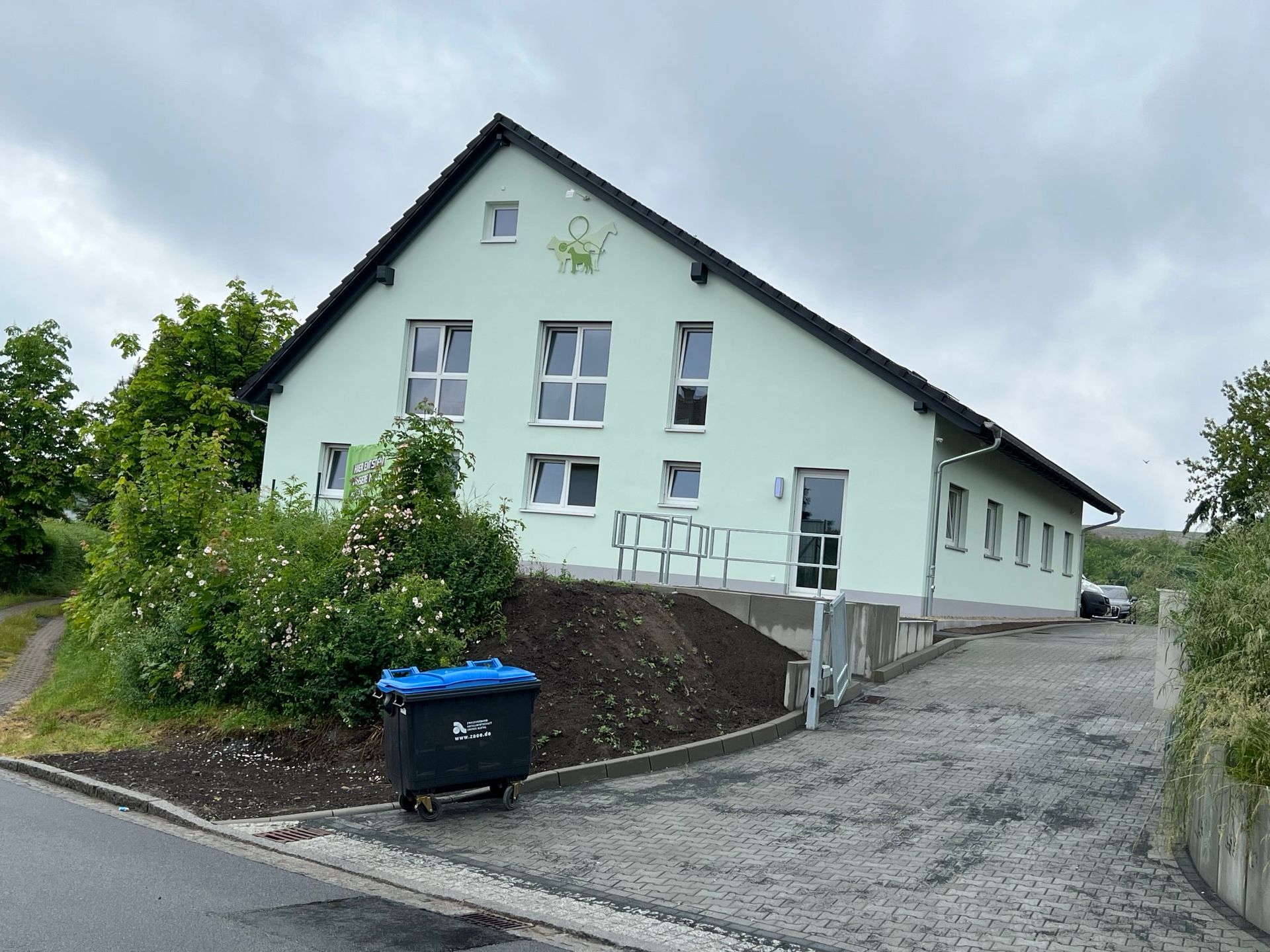 Firmengebäude der Elektroinstallation mit Einfahrt und Grünflächen